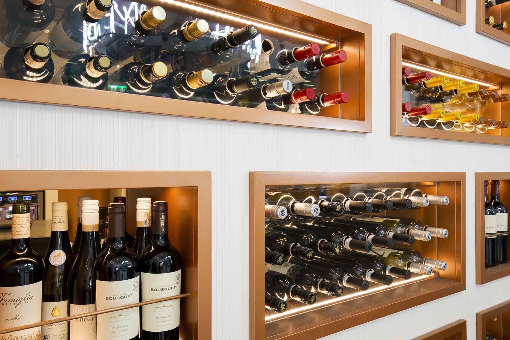 Wine display in unit with textured wall covering and copper boxes