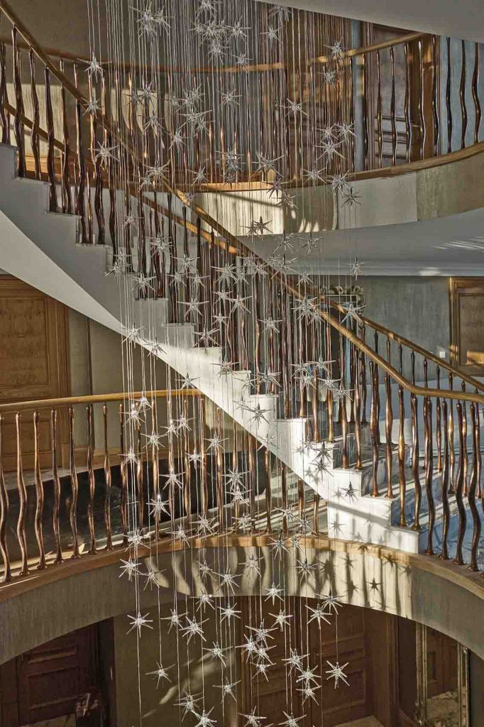 Cascading stars light feature in open staircase, copper balustrade