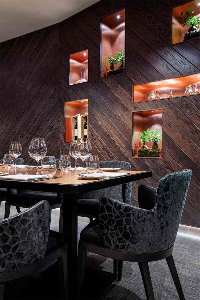 Private dining room, angled timber panelled walls, copper details, integrated lighting