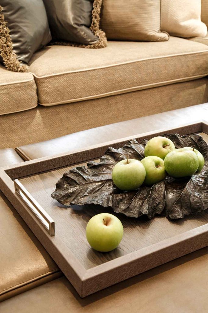 Leather tray with green apples and linen sofa vignette