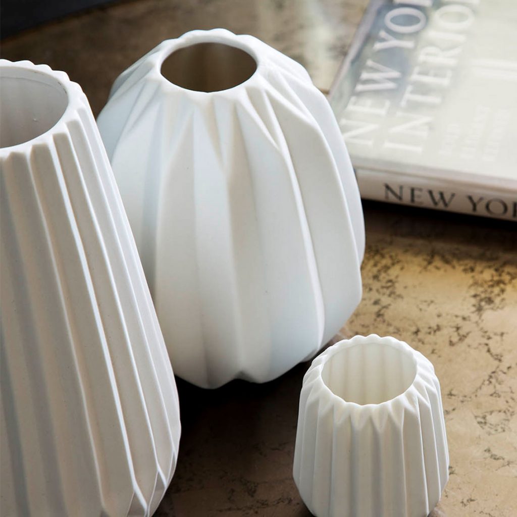 Table scape of white porcelain modern vases, eglomise coffee table