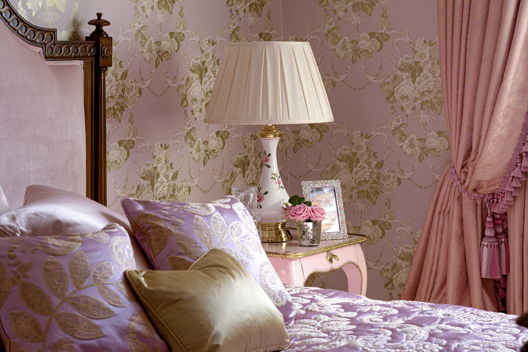 Girls bedroom, pink and gold floral wall paper, pink silk upholstered headboard, gold accents