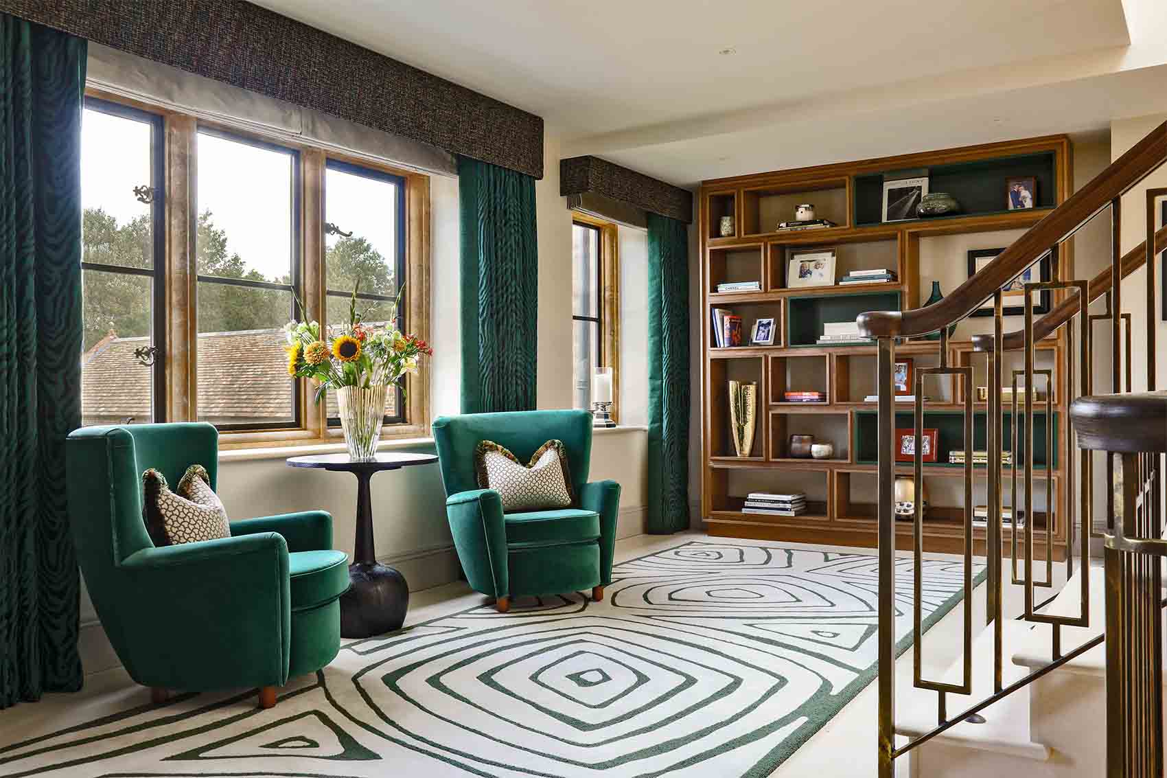 Silk and wool design rug, modern display cabinet, green velvet arm chairs, silk curtains